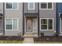 Attractive townhouse with a covered entry featuring muted siding, contemporary windows, and manicured landscaping at 2115 Coretta Way, Indianapolis, IN 46202