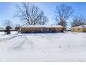 Single story home with brick exterior, snow-covered yard and mature trees at 2749 W 900 S, Pendleton, IN 46064