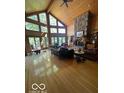 Bright living room with wood-paneled walls, floor-to-ceiling windows and fireplace at 3932 W Poplar Point Ct, Trafalgar, IN 46181