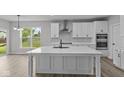 Bright kitchen featuring all white cabinets, countertops, and a large center island at 5040 Carmine St, Brownsburg, IN 46112
