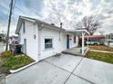 Charming white home showcasing a spacious driveway, covered porch, and neat landscaping at 5103 E St Clair St, Indianapolis, IN 46219
