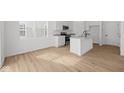 Bright white kitchen features an island with a sink, stainless steel appliances, and wood floors at 5119 Rolling Meadow Blvd, Indianapolis, IN 46237