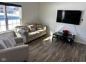 Bright living room with a neutral sofa, armchairs, wood floors, and a view of the outdoors at 5120 Maywood Dr, Whitestown, IN 46075