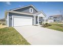 Well-built home featuring gray siding, white trim, an attached garage, and a concrete driveway at 5146 Cartland Dr, Indianapolis, IN 46239
