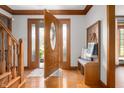 Bright foyer with hardwood floors, coat rack and bench with easy access to the front door at 7018 W Anton Way, New Palestine, IN 46163