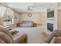 Bright living room with a fireplace, a large window with curtains, and neutral-toned furniture at 11 Stratford Way, Danville, IN 46122