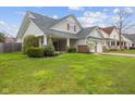 Charming home featuring a two-car garage, front porch, and well-maintained lawn at 11130 Sanabria Dr, Indianapolis, IN 46235