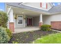 Charming front porch with brick columns, hanging flower baskets, and double red doors at 11130 Sanabria Dr, Indianapolis, IN 46235