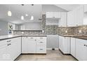Well-lit kitchen with white cabinets, stylish backsplash, and modern countertops at 1408 W Banta Rd, Indianapolis, IN 46217