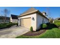 Attractive home featuring a beige garage door, well-maintained greenery, and a clean driveway at 1655 Rosebud Ln, Greenwood, IN 46143