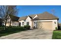 Beautiful white brick home with a manicured lawn and driveway leading to a beige garage at 1655 Rosebud Ln, Greenwood, IN 46143