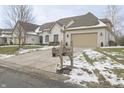Beautiful white brick home featuring an attached garage, manicured shrubs and long driveway at 1655 Rosebud Ln, Greenwood, IN 46143