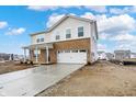 Stylish two-story home with a brick and vinyl facade, attached two-car garage, and a long freshly poured concrete driveway at 2004 Foothill Dr, Greenfield, IN 46140
