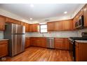 Well-lit kitchen featuring stainless steel appliances, wood cabinets, and stylish countertops at 2566 S Ritter Ave, Indianapolis, IN 46203