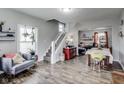Bright living area featuring hardwood floors, open staircase, and seamless flow to the dining area at 2962 Station St, Indianapolis, IN 46218