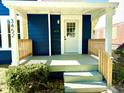 Charming covered front porch with a white door and wood railing at 3452 N Bancroft St, Indianapolis, IN 46218