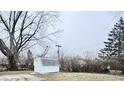 Backyard featuring a small storage shed, bare trees, and overcast lighting at 3527 N Wittfield St, Indianapolis, IN 46235