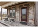 Cozy front porch with stone accents, seating, and a stylish, recently installed front door at 3764 S 475 W, Trafalgar, IN 46181
