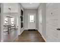 Inviting hallway with wood flooring, white doors, and decorative wall art leading to living area at 4040 Jacoby Pl, Indianapolis, IN 46268