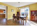 Bright dining room with wood floors, a chandelier, and large window overlooking the neighborhood at 5147 Nicodemus Dr, Plainfield, IN 46168