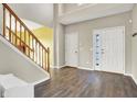 Inviting foyer with wood-look floors, staircase with wooden railing, and bright natural light entering through the front door at 5147 Nicodemus Dr, Plainfield, IN 46168
