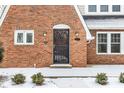 Close-up of the brick home's front entrance, featuring a decorative door and exterior lights at 5715 N Delaware St, Indianapolis, IN 46220