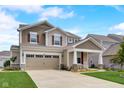 Attractive home with a well-kept lawn, a double garage, and a cozy front porch perfect for relaxing at 6648 Harvest Moon Ln, Whitestown, IN 46075
