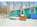 Charming turquoise home featuring an inviting deck and winter wonderland views at 7166 N Oak Ridge Rd, Morgantown, IN 46160
