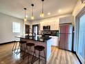 Modern kitchen with stainless steel appliances, a black countertop island, and a brick accent wall at 1046 Nelson Ave, Indianapolis, IN 46203