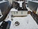 Aerial view of a backyard with a firepit, storage shed, and a privacy fence covered in winter snow at 10885 Walnut Grove Bnd, Camby, IN 46113