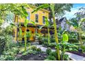 Striking yellow home with a landscaped front yard and a welcoming porch at 1409 N Park Ave, Indianapolis, IN 46202