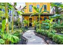 Inviting yellow home with lush landscaping and a charming walkway at 1409 N Park Ave, Indianapolis, IN 46202