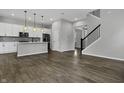 Open-concept living room and kitchen with hardwood floors and a staircase at 1538 Cloverdon Dr, Westfield, IN 46074