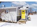 Charming single-story home featuring a yellow door, gray facade, and well-maintained landscaping, covered in snow at 180 N Indiana St, Mooresville, IN 46158