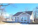 Well-maintained single Gathering house features neutral siding, a covered porch, and manicured landscaping at 1967 Hovey St, Indianapolis, IN 46218