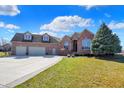 Beautiful brick home with a three-car garage, well-manicured lawn, and mature landscaping under a sunny sky at 2110 Cheviot Ct, Greenwood, IN 46143