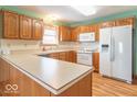 A kitchen with wooden cabinets, white appliances, countertops, and a white tile backsplash at 2979 Colony Lake E Dr, Plainfield, IN 46168