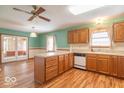 Traditional kitchen featuring wood cabinets, laminate floors, and an island overlooking a bright adjoining space at 2979 Colony Lake E Dr, Plainfield, IN 46168