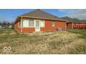 A brick home with a rear entry door and small windows, providing a glimpse of the outdoor space at 2979 Colony Lake E Dr, Plainfield, IN 46168