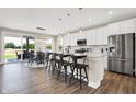 Open-concept kitchen with a large island, white cabinets, stainless steel appliances, and dining area at 449 Hidden Hills Dr, Pittsboro, IN 46167