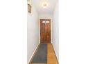Bright foyer with wooden front door, hardwood flooring, and white walls for a welcoming entrance at 5838 Brouse Ave, Indianapolis, IN 46220