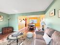 Bright living room featuring a cozy couch, hardwood floors, and a view into the dining area at 6740 Live Oak Ct, Indianapolis, IN 46214