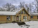 Home exterior featuring stone and wood paneling and a peaked roof over the entryway at 810 N Cherry Wood Ln, Muncie, IN 47304