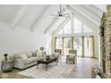 Living room with vaulted ceiling, many windows, and a stone fireplace at 810 N Cherry Wood Ln, Muncie, IN 47304