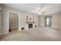 Cozy living room with carpet, neutral walls, vintage fireplace and a ceiling fan for comfortable living at 9841 E Raymond St, Indianapolis, IN 46239