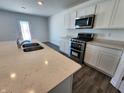 Modern kitchen with stainless steel appliances, white cabinetry, an island and hard surface countertops at 11322 N Quillow Way, Monrovia, IN 46157