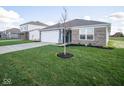 Well-maintained home featuring a two-car garage, brick accents, and lush green lawn at 1253 Fleming Dr, Greenfield, IN 46140