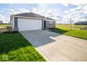 Inviting home featuring an attached garage, brick detailing, and a well-kept lawn at 1253 Fleming Dr, Greenfield, IN 46140
