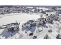 Winter aerial view of homes in a suburban neighborhood surrounding a snow-covered pond with waterfront properties at 12773 Broncos Dr, Fishers, IN 46037