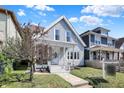 Charming two-story home with light gray siding, a welcoming front porch, and a beautifully landscaped lawn at 1339 S East St, Indianapolis, IN 46225